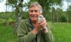 Keith Broomfield - who has written a new nature book - pictured with a kestrel chick.