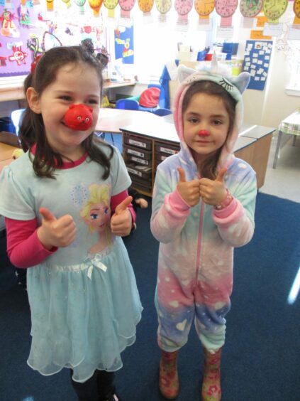 Two primary school-aged children dressed up for Red Nose Day