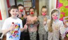 Five primary school age children wearing red noses for Comic Relief