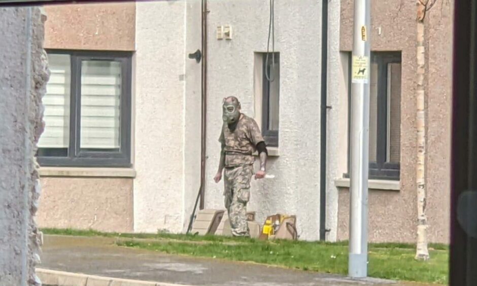 The man standing in the street wearing a gas mask on Polvanie View.