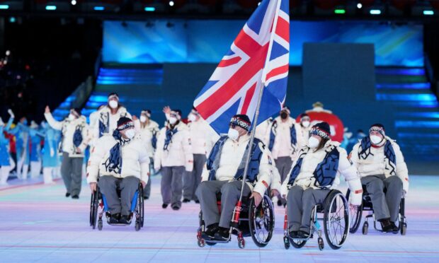 Meggan Dawson-Farrell (Wheelchair Curling) and Gregor Ewan (Wheelchair Curling) carry the flag for the Great Britain Paralympic team in Beijing.