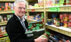 George Montgomery  filling shelves in the food bank. Picture by Paul Glendell.