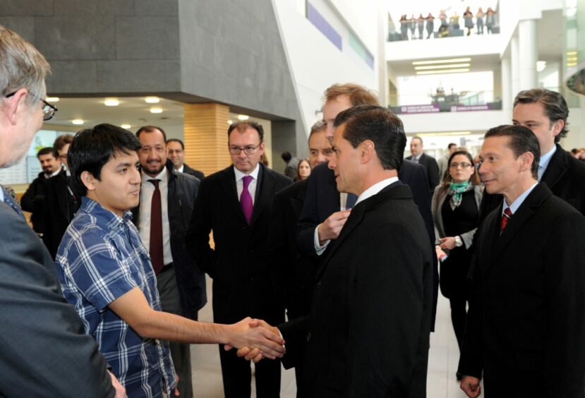 Nexican President Pena Nieto shakes hands with a man in a blue checkered shirt