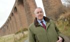 Highland Councillor Duncan Macpherson with the graffiti struck Culloden Viaduct. Picture by Sandy McCook.