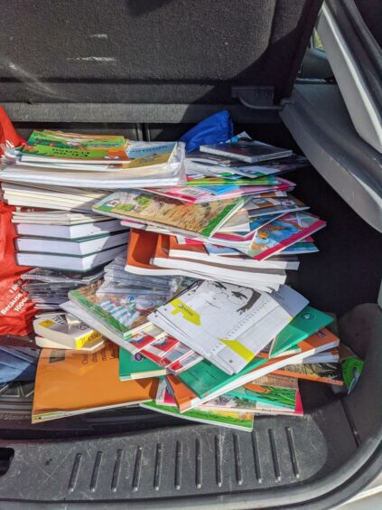 Books moved to a car boot after being saved from skip. 