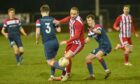 Formartine's Jonny Smith, centre, tries to get the better of Rhys Clark, left, and Liam Norris of Turriff