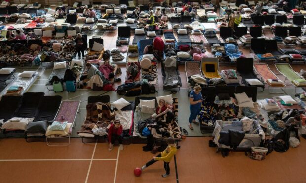 People who fled the war in Ukraine rest inside an indoor sports stadium being used as a refugee center, in the village of Medyka, a border crossing between Poland and Ukraine (Photo: Petros Giannakouris/AP/Shutterstock)