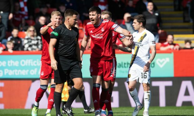 Referee Grant Irvine and Declan Gallagher of Aberdeen in the game against Livingston.