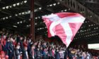 Aberdeen fans in the red shed at Pittodrie waving a red saltire flag