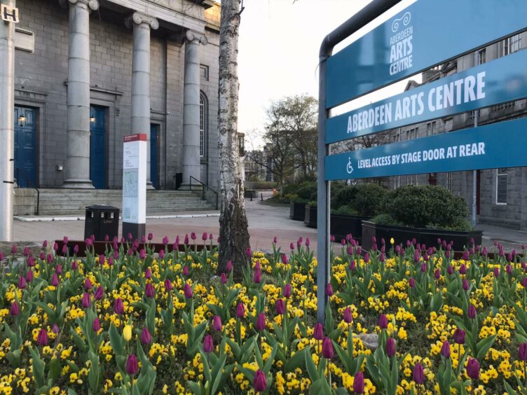 The sign Aberdeen Arts Centre stands in a flowerbed.