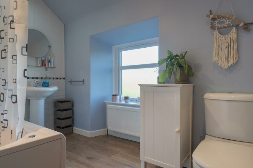 The bathroom with light blue walls.