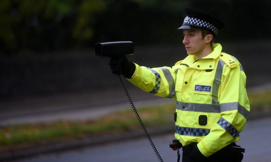 Policeman holding a radar speed gun.
