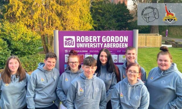 Youngsters in front of Robert Gordon University sign.