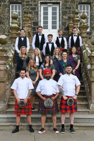 The Meldrum House team and chefs wearing tartan clothing and kilts.