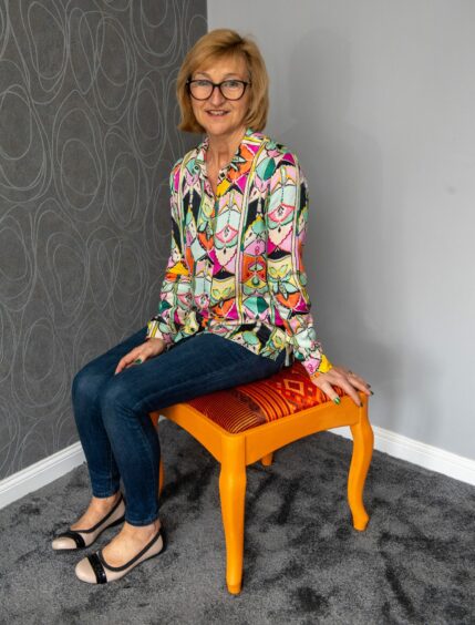 Carol sitting on a stool