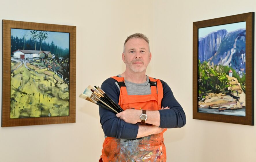 John O'Neill stood in front of a selection of his paintings displayed in his home. 