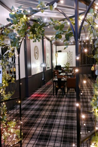 The function suite with tartan carpet floor and a gate decorated with leaves and fairy lights.