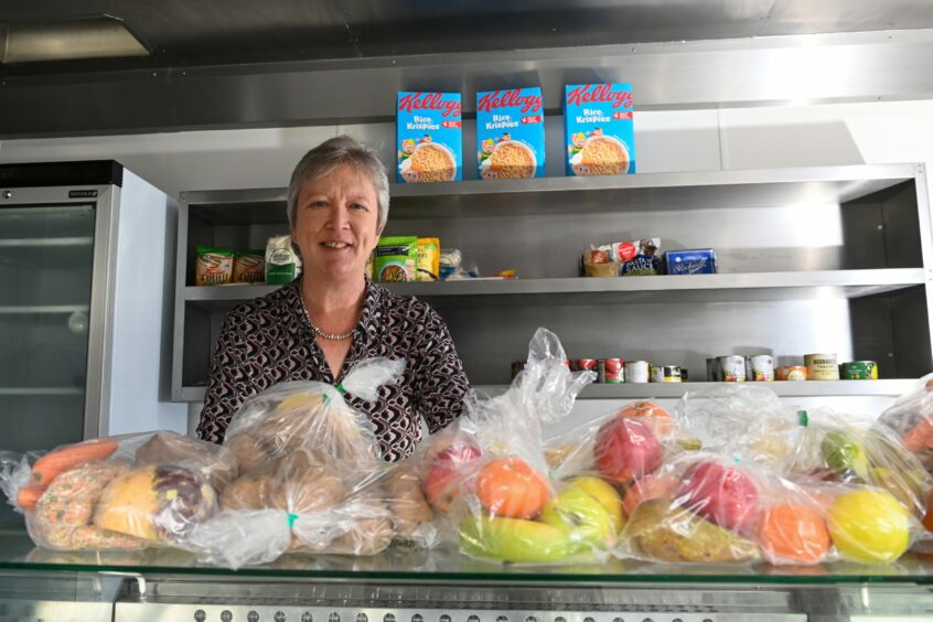 Fiona Rae in a kitchen with bags of fruit and vegetables.