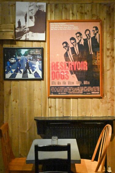 A wall in Spin decorated with Reservoir Dogs and Beatles posters.