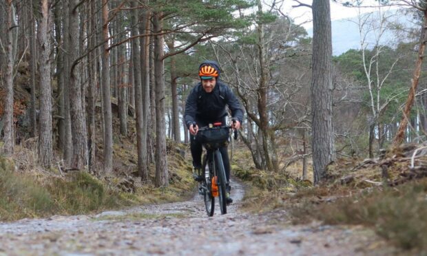 Markus riding on a gravel track parallel  to the NC500 near Torridon.