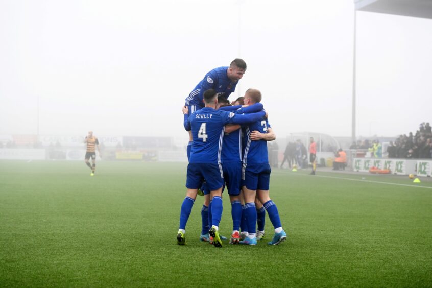 Cove Rangers players celebrate amid the fog at the Balmoral Stadium