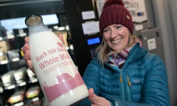 Jo with a bottle of the milk they produce at Rootfield Farm.
