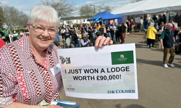 A delighted Jean Stewart of Bankfoot shows off the winning ticket. Picture by Sandy McCook.