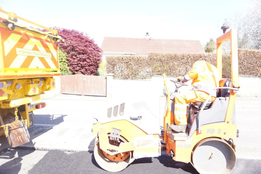 Steamroller flattens the road