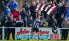 Scott Barbour celebrates scoring for Fraserburgh against Rothes by waving a supporter's flag