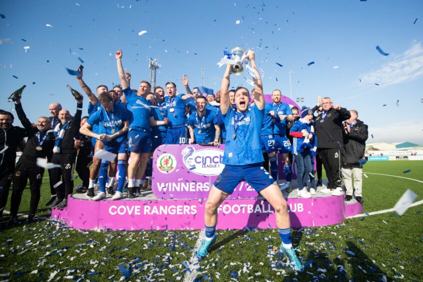 Cove Rangers defender Harry Milne, centre, lifts the League One title