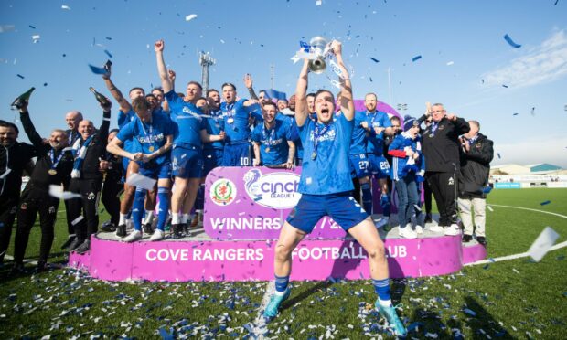 Cove Rangers defender Harry Milne, centre, lifts the League One title