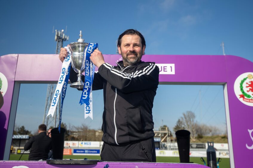 Paul Hartley holding up the League One trophy