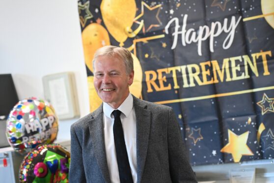 Gordon Young with a retirment banner and balloons