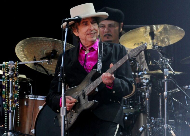 Bob Dylan performing with a guitar