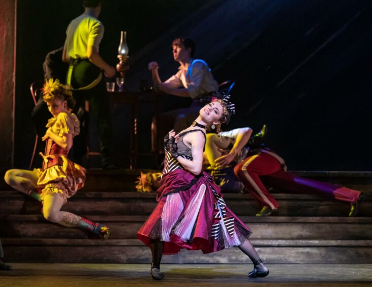 A dancer in a hot pink flowing skirt posing for the audience