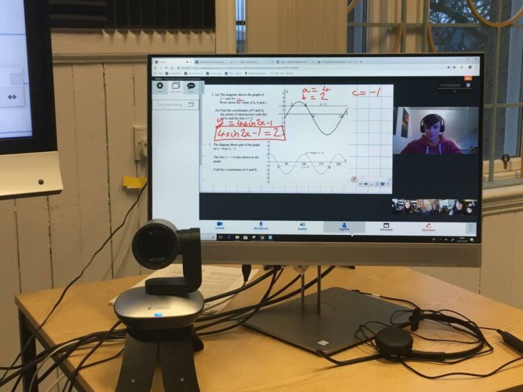 A webcam and a screen showing algebra calculations.