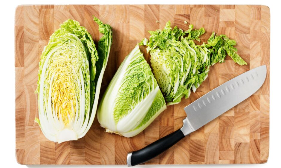 Cut up raw cabbage on a wooden chopping board