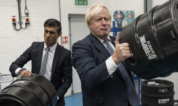 Chancellor Rishi Sunak (left) and Prime Minister Boris Johnson pose for photos during a brewery visit in 2021 (Photo: Dan Kitwood/AP/Shutterstock)