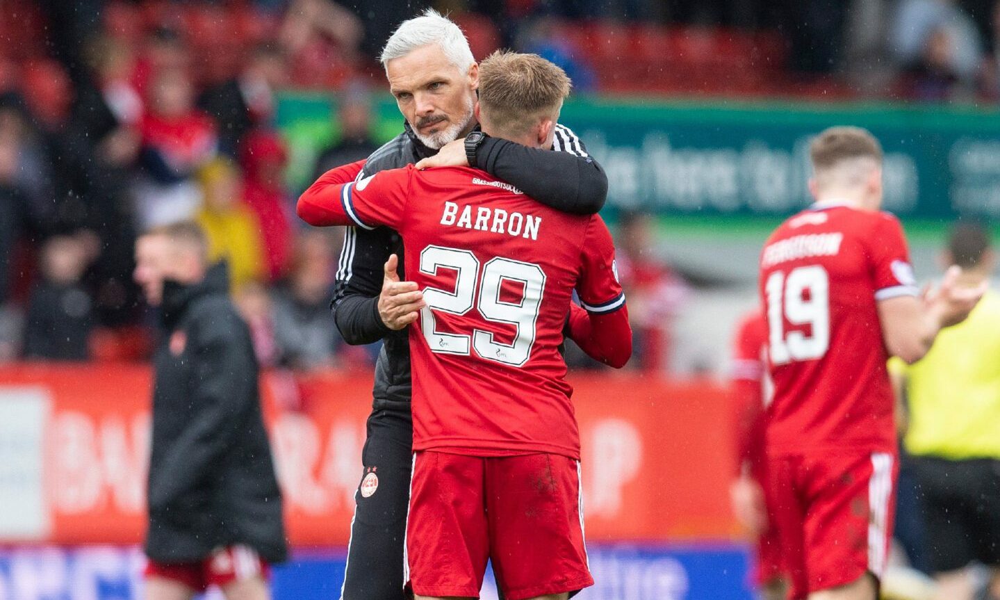 Aberdeen manager Jim Goodwin hugging Connor Barron on the football pitch.