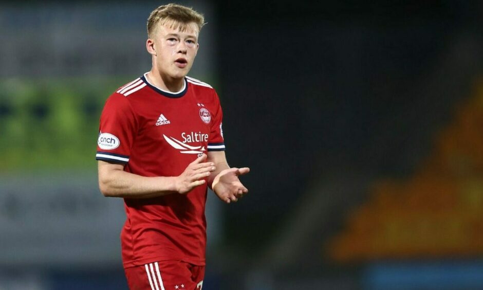 Aberdeen FC player Connor Barron applauding on the football pitch.