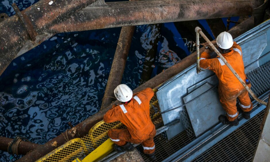 Two workers at jack up oil rig leg when checking everything in rig move operation; Shutterstock ID 369506348; Purchase Order: -