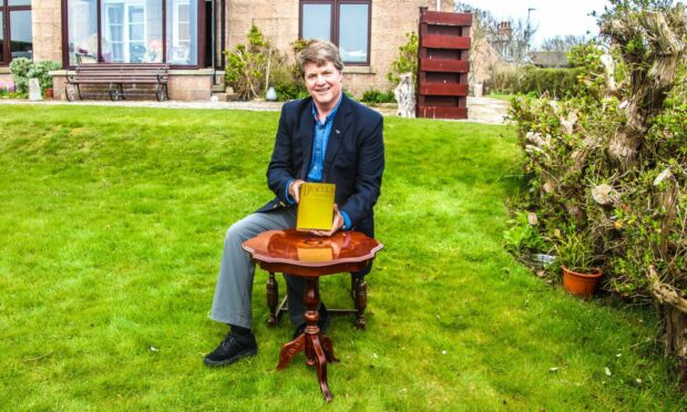 Dacre Stoker in Cruden Bay holding his ancestor's personal copy of Dracula. The book was used by Bram Stoker to mark cuts for the paperback - work he carried out on this exact spot. Supplied by Mike Shepherd.