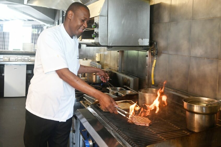 Marcliffe head chef John Jeremiah grilling a steak in the hotel's kitchen.