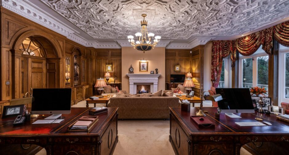 Dalhebity House's large study with traditional desks, moulded ceilings and a large seating area and fireplace. It leads to a balcony
