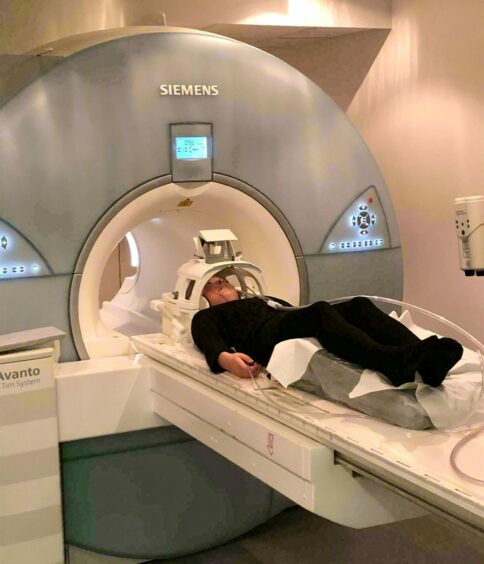 Olivia going into an MRI scanner. She's had many MRI and CT scans over the years.