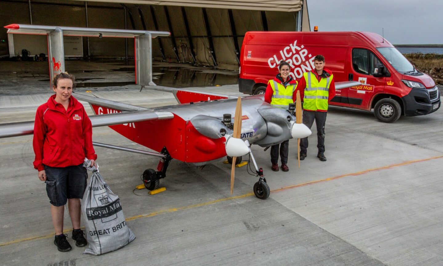 Royal Mail staff either side of the drone