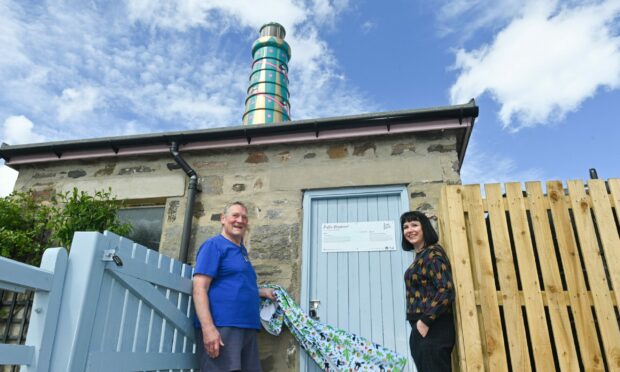 John Anderson and artist Suzanne Scott from Whimsical Lush unveil the new plaque for Clan's lighthouse that is now proudly overlooking Sandend Holidays. Picture by Jason Hedges.