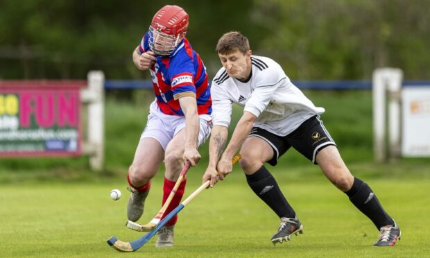 Calum Grant (Kingussie) with Fraser Heath (Lovat) in the MacTavish Cup semi-final played at The Dell, Kingussie.
