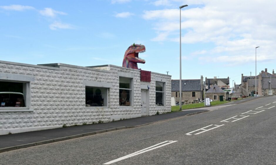 The Outlet on Seafield Street, Cullen with its painted dinosaur on the roof.