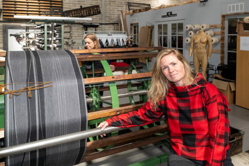 Prickly Thistle founder Clare Campbell in front of a loom.